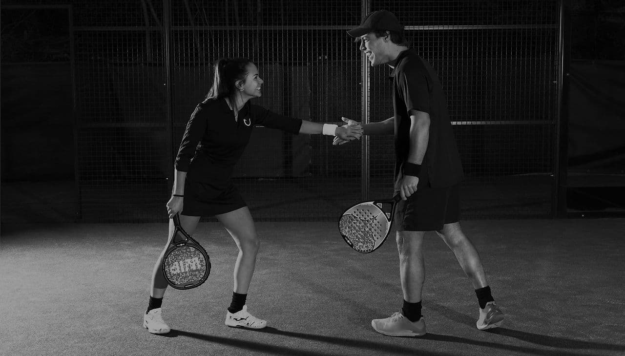Two padel players shaking hands